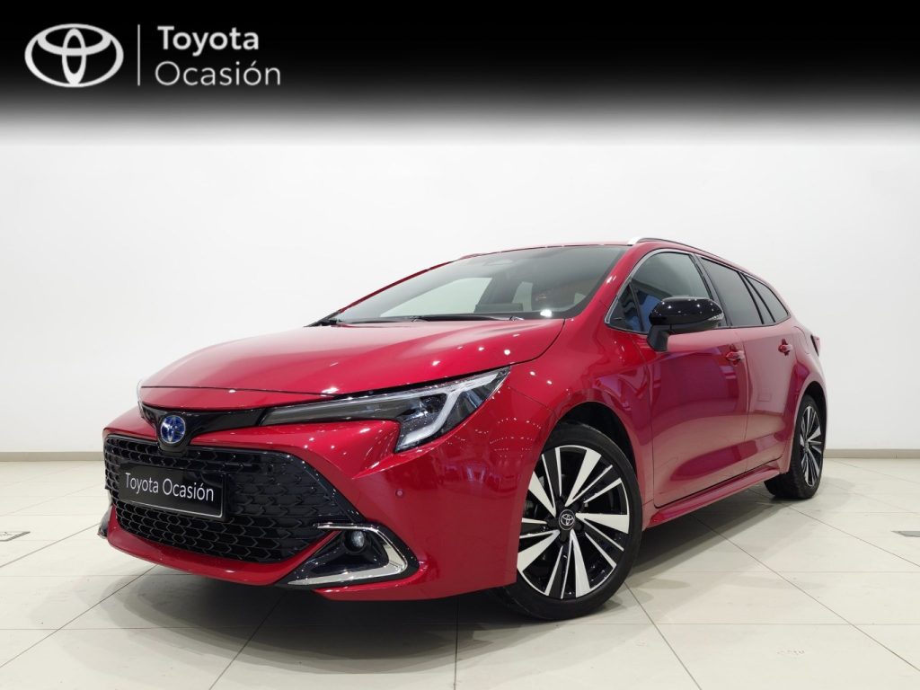 Red Toyota car in a showroom, front three-quarter view with a black grille and large alloy wheels.