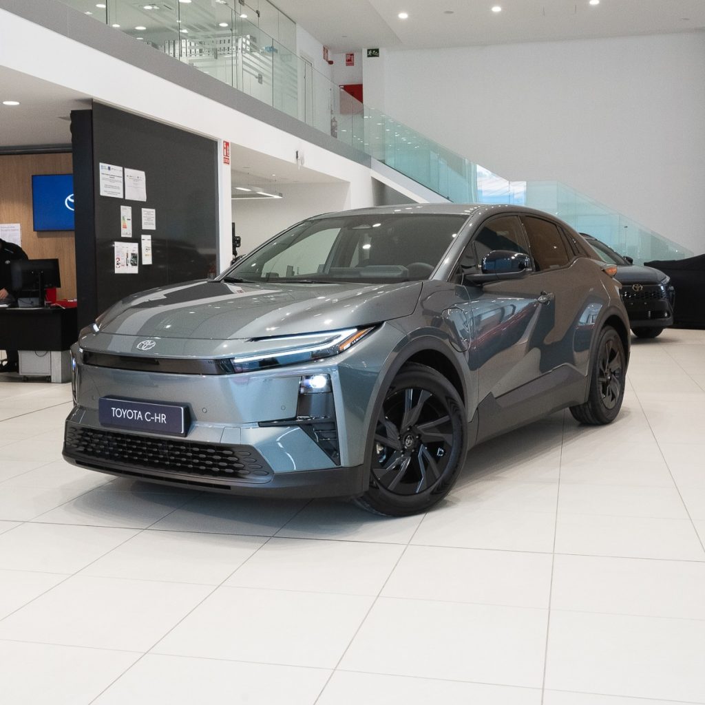 Grey Toyota C-HR on a showroom floor, front three-quarter view showcasing its design and wheels
