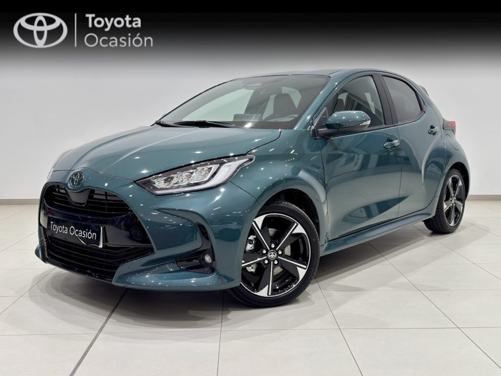 Front three-quarter view of a teal Toyota hatchback in a showroom, with a Toyota Ocasión banner in the background.