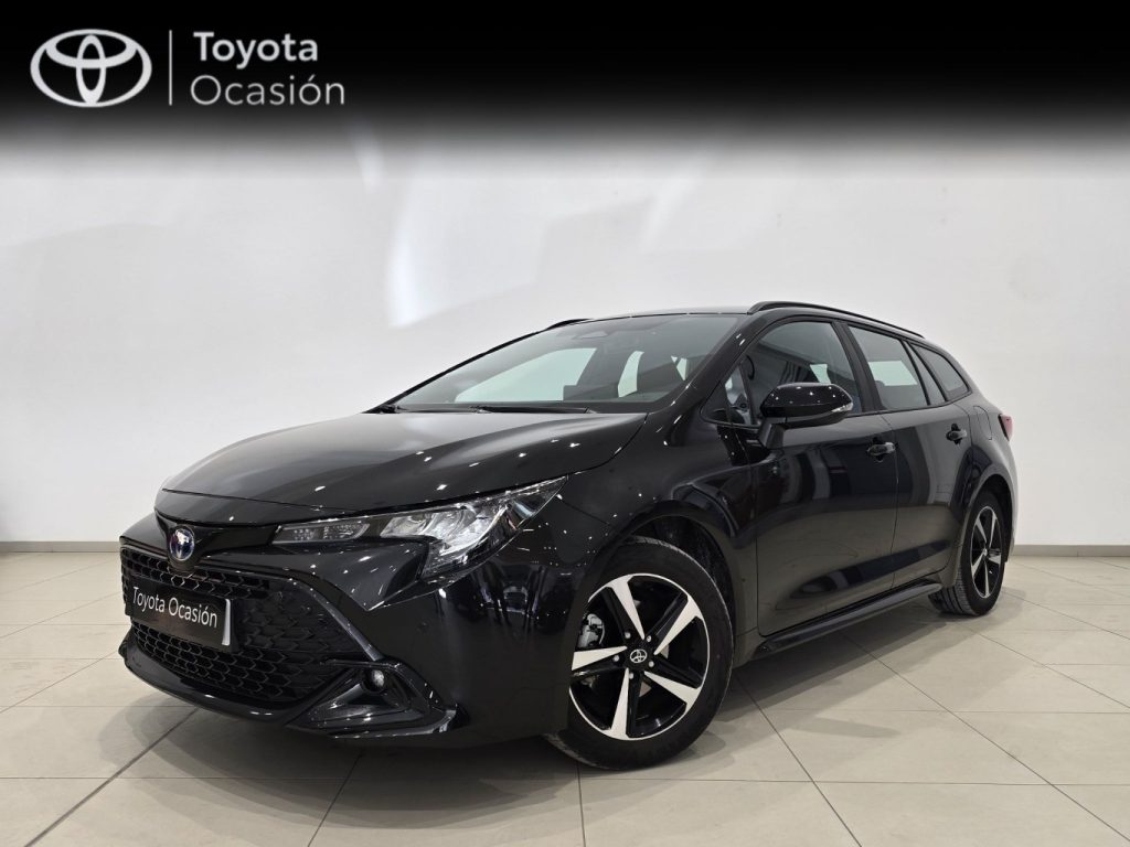 Front three-quarter view of a black Toyota sedan in a showroom with a 'Toyota Ocasión' banner above it, glossy finish visible on the car.