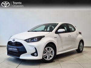 White Toyota hatchback on showroom floor, front-left angle with 'Toyota Ocasión' branding on the plate area