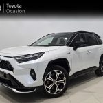 White Toyota SUV in a showroom, three-quarter front view showing grille, headlights, and large alloy wheels with black accents; banner reads 'Toyota Ocasión' in the background.