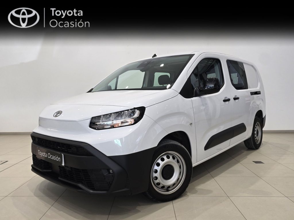 White Toyota van shown in a showroom from the front-left three-quarter view, with Toyota Ocasión branding in the background.