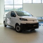 Toyota PROACE 2026 VAN 1.5D 120CV GX PLUS ID: 8804 White Toyota Proace van on a showroom floor with large windows behind it.